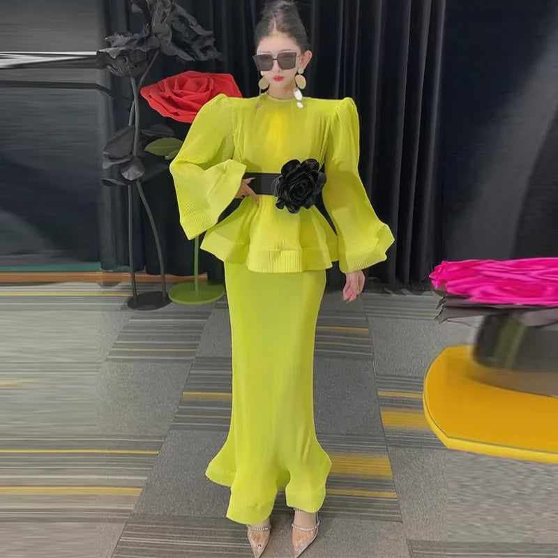 A turquoise two-piece outfit with puff sleeves and ruffles, consisting of a shirt and a matching skirt, displayed on a hanger.