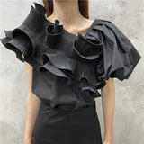A mannequin displaying a white skew collar blouse with irregular ruffles and puff short sleeves.