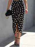 Woman wearing a black polka dot skirt with a blurred background