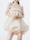 Woman wearing a strapless beige dress with a white background