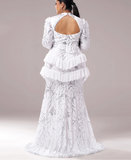 White lace dress with ruffled layers on a plain background