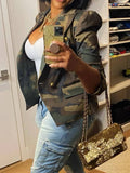 Person wearing a camouflage jacket and holding a gold sequin handbag.