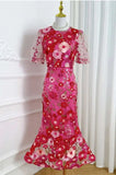 Pink floral dress on a mannequin against a white curtain background