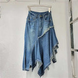 Blue denim skirt on a hanger against a white wall