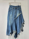 Blue denim skirt with fringe details on a hanger against a white wall