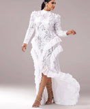 Woman wearing a white lace dress with a high-low hem on a gray background