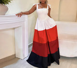 Woman wearing a white, red, and black dress in an indoor setting.