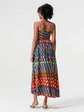 Woman wearing a colorful geometric patterned dress on a white background